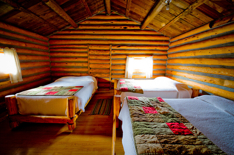 Three beds in a wooden cabin