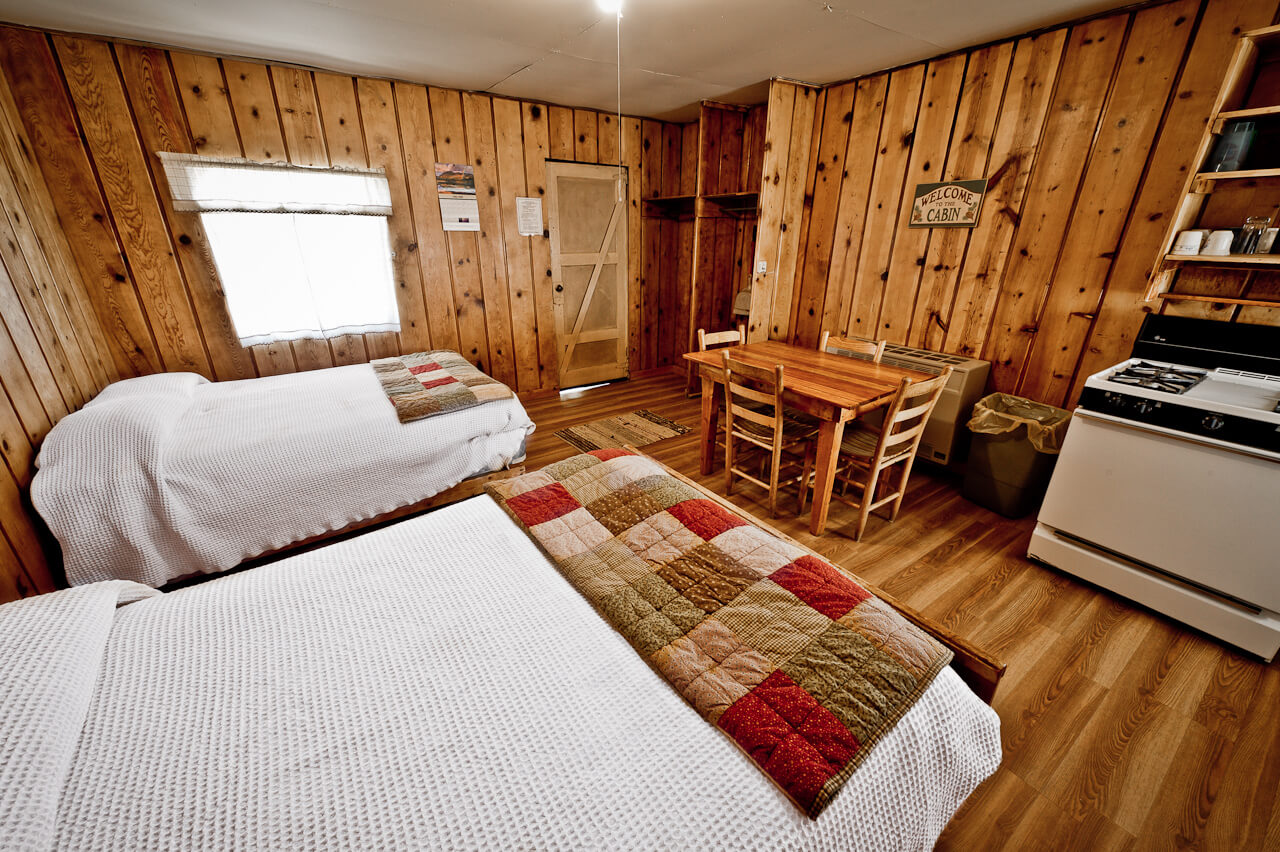 Wooden cabin with two white beds