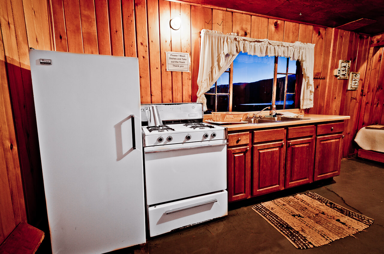 Refrigerator and stove inside a wooden cabin