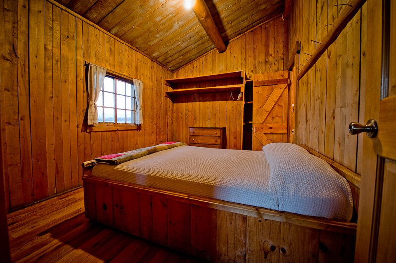 Wooden cabin with white bed