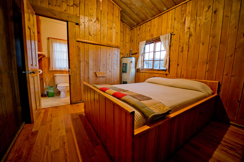 Wooden cabin with a white bed