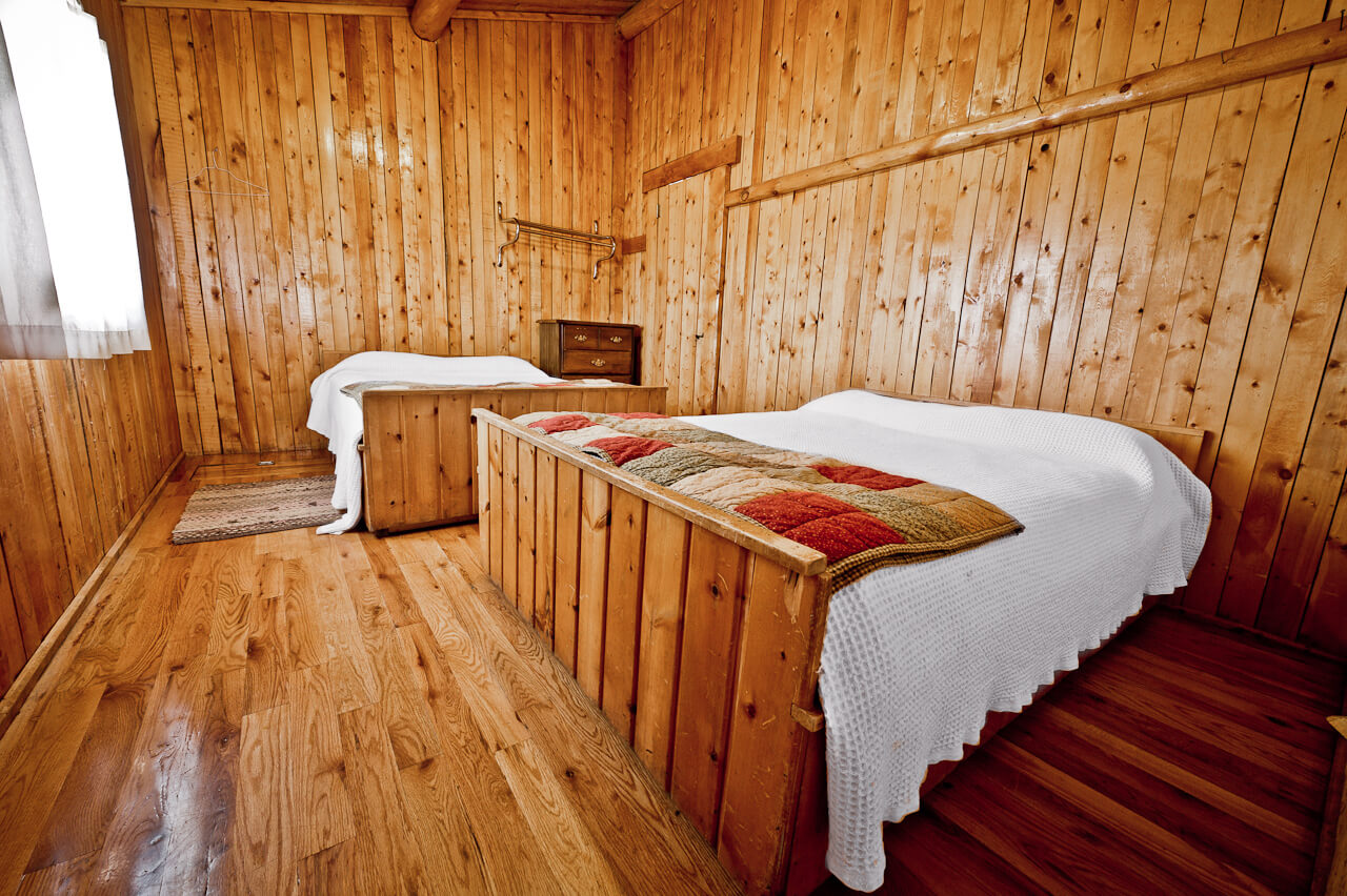 Wooden cabin with two white beds
