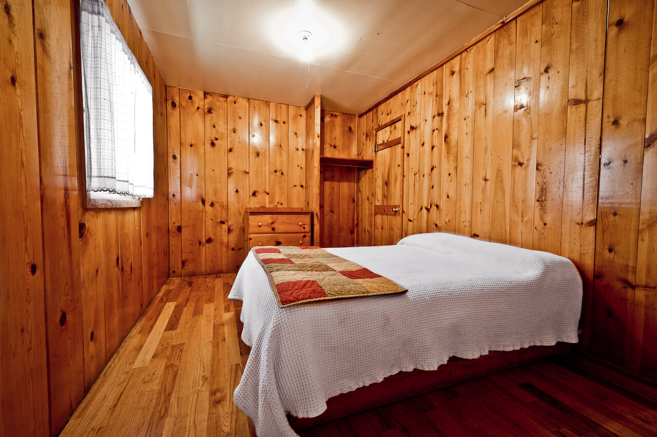 Wooden cabin with white bed