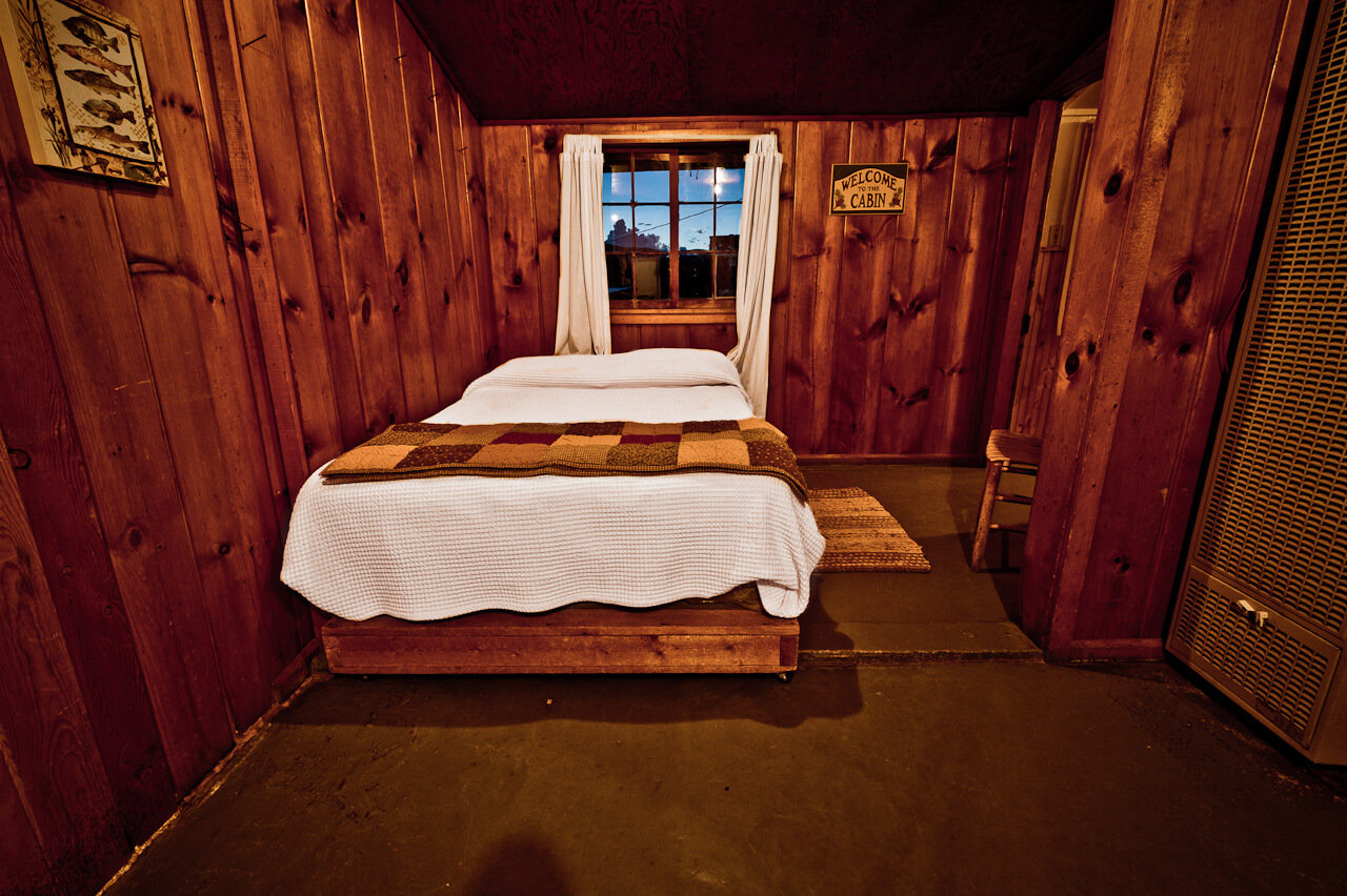 Wooden cabin with one white bed