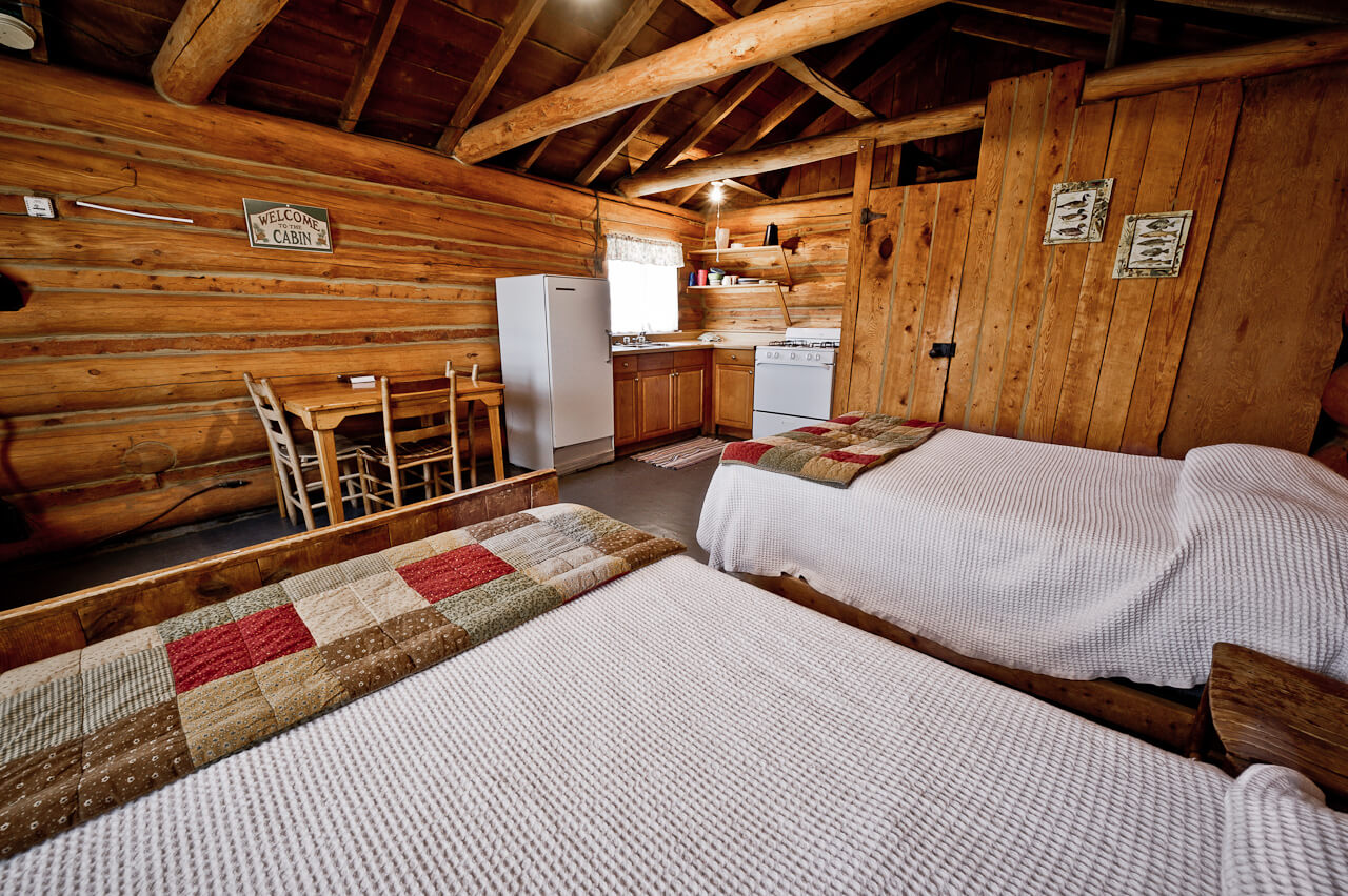 Wooden cabin with two beds and a refrigerator