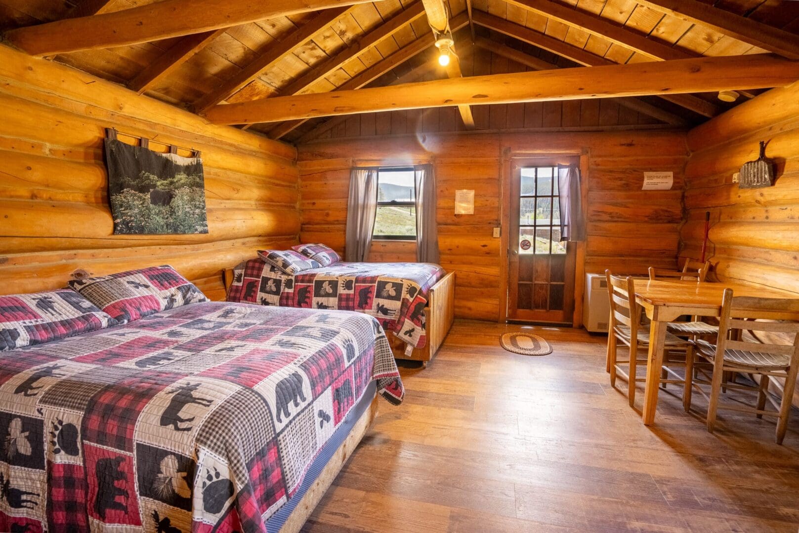 A Fully Wooden Room With Two Double Beds and a Table